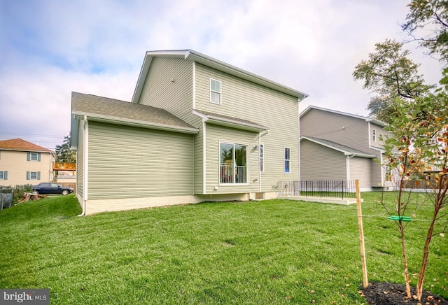 rear view of house featuring a lawn