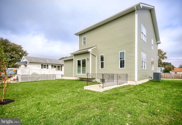 back of house featuring a yard and central AC