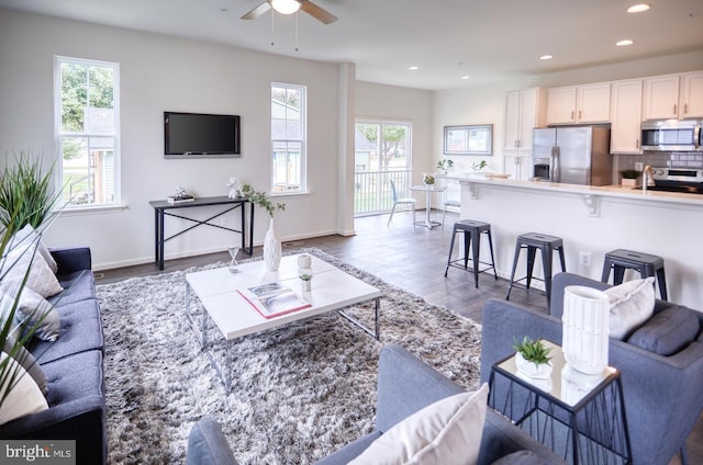 living room featuring hardwood / wood-style floors, ceiling fan, and a healthy amount of sunlight