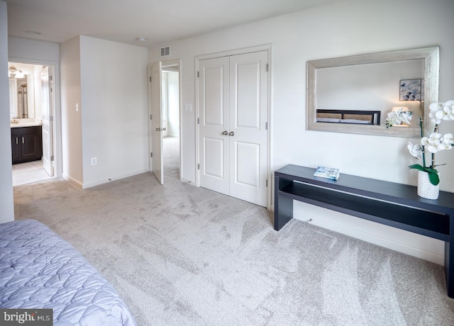 bedroom with light carpet and a closet