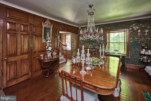 dining room with dark wood-type flooring, crown molding, and an inviting chandelier