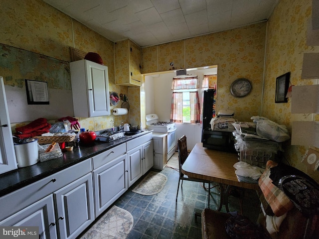 kitchen featuring white cabinetry, sink, and white range with gas stovetop