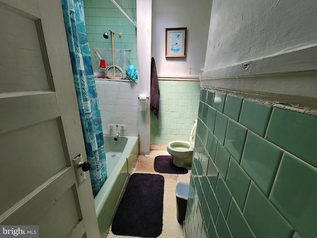 bathroom with toilet, shower / bathtub combination with curtain, and tile walls