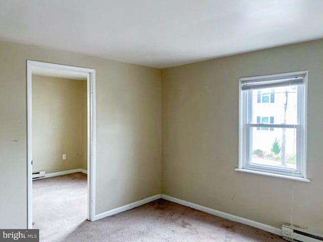 empty room featuring light carpet and a baseboard radiator