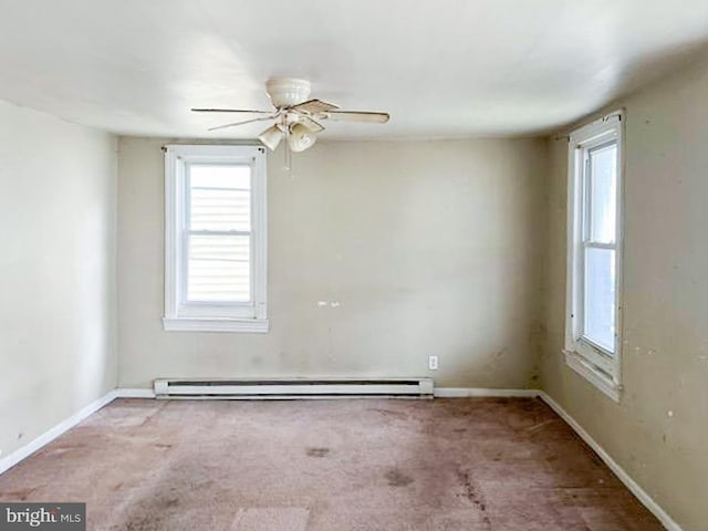 carpeted spare room with ceiling fan and a baseboard heating unit