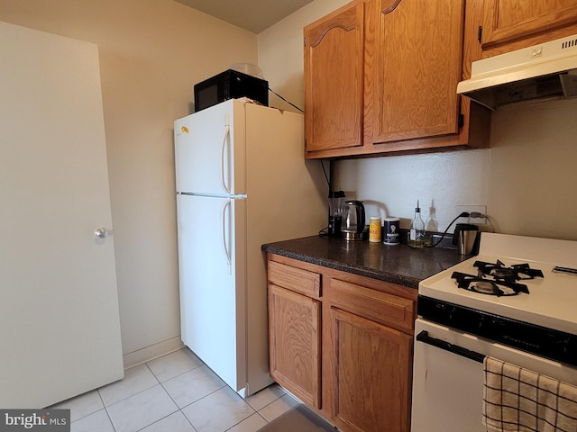 kitchen with light tile patterned flooring and white appliances