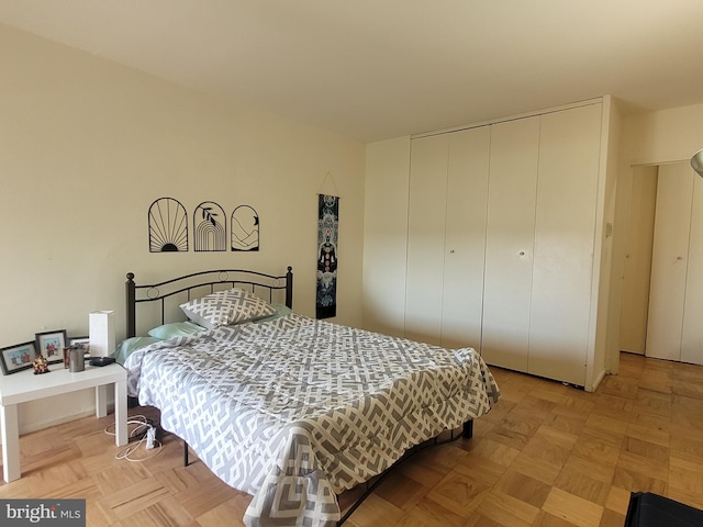 bedroom with light parquet flooring and a closet