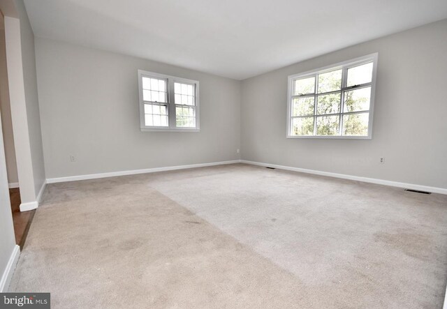 spare room featuring light colored carpet