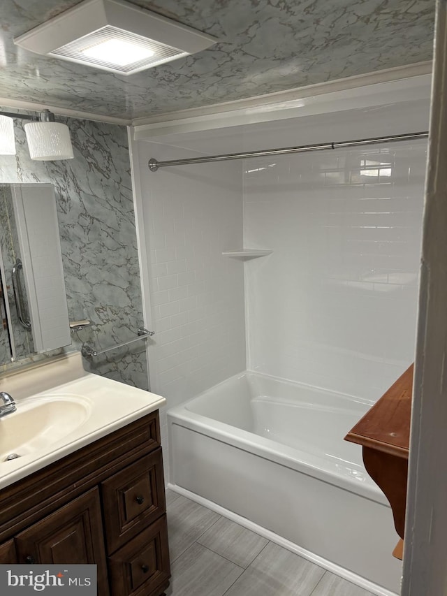 bathroom with vanity, washtub / shower combination, and tile walls