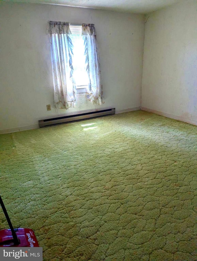 spare room featuring baseboard heating and carpet floors