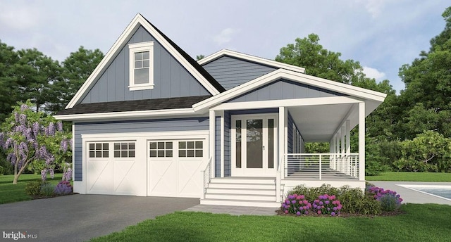 view of front facade with covered porch, a garage, and a front lawn