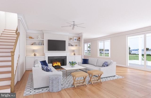 living room with ceiling fan, built in features, light wood-type flooring, and ornamental molding