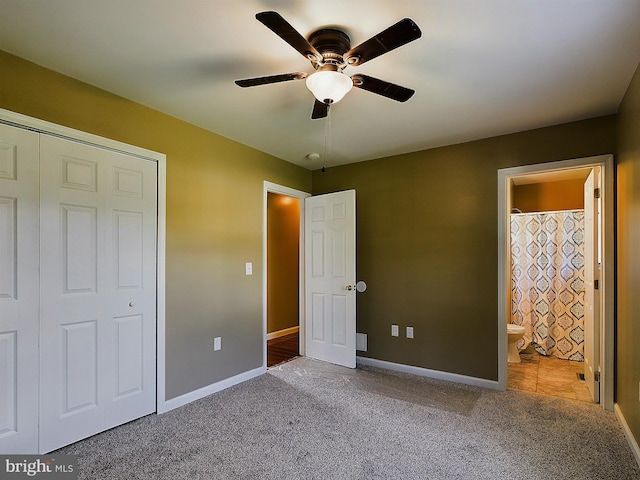 unfurnished bedroom with connected bathroom, ceiling fan, a closet, and carpet