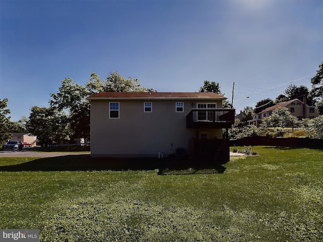 view of side of home with a lawn and a balcony