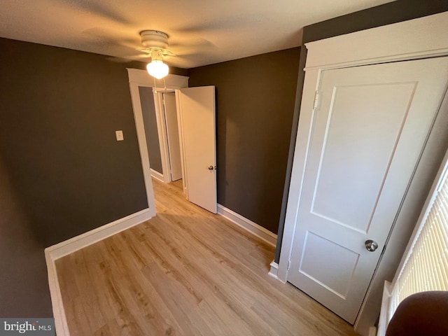 unfurnished bedroom with ceiling fan, a closet, and light wood-type flooring