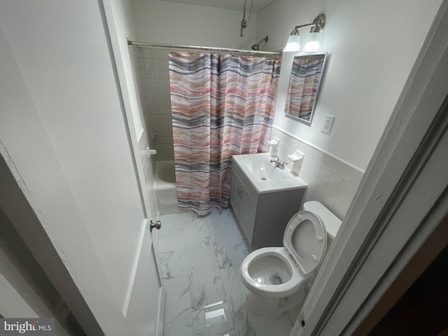 full bathroom featuring shower / bath combo with shower curtain, vanity, tile walls, and toilet