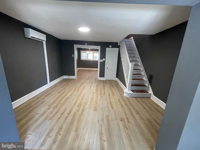 basement featuring a wall mounted air conditioner and light wood-type flooring