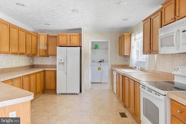 kitchen featuring white appliances, crown molding, sink, independent washer and dryer, and a textured ceiling