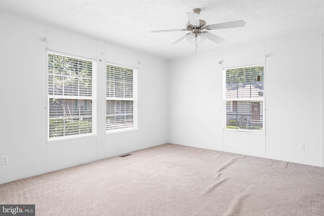 unfurnished room with carpet flooring, a textured ceiling, and ceiling fan