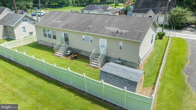 back of property with a lawn and central air condition unit