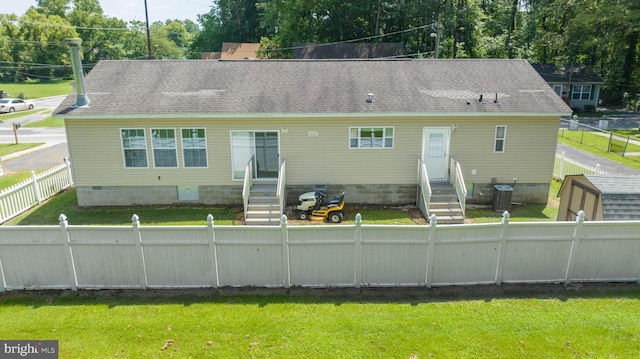 back of property featuring central AC and a lawn