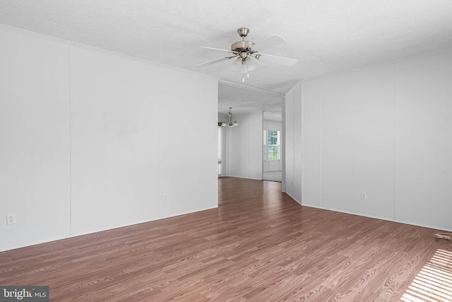 unfurnished room featuring hardwood / wood-style floors, ceiling fan with notable chandelier, and a textured ceiling