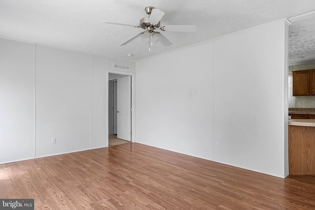 spare room with hardwood / wood-style flooring, ceiling fan, and a textured ceiling