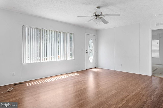 foyer entrance with ceiling fan, wood-type flooring, and a textured ceiling