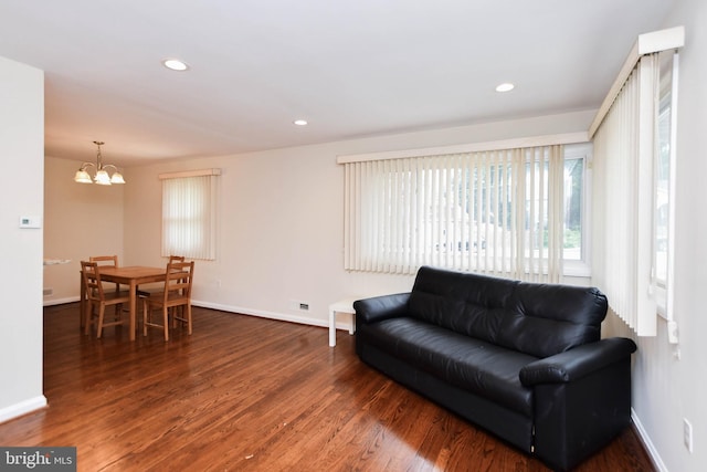 living room with dark hardwood / wood-style floors and a chandelier