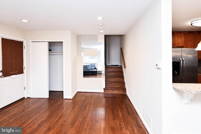 interior space featuring stainless steel fridge, dark hardwood / wood-style flooring, and a closet