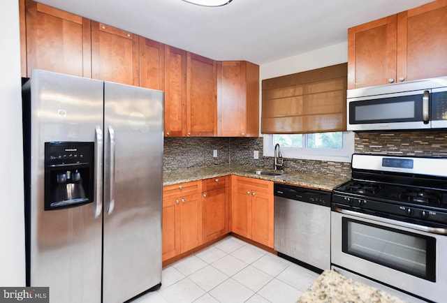 kitchen featuring light tile patterned flooring, sink, tasteful backsplash, light stone counters, and stainless steel appliances