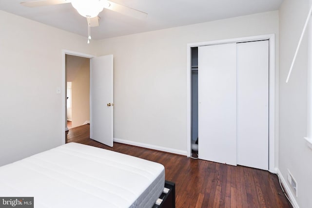 bedroom with dark hardwood / wood-style flooring, a closet, and ceiling fan