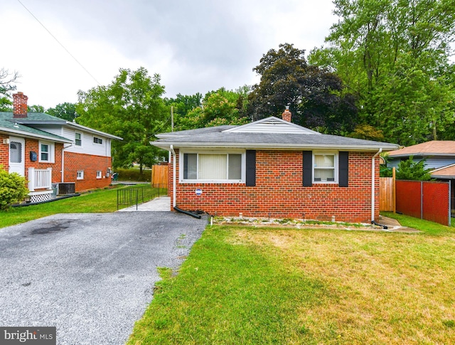 bungalow-style house with cooling unit and a front yard