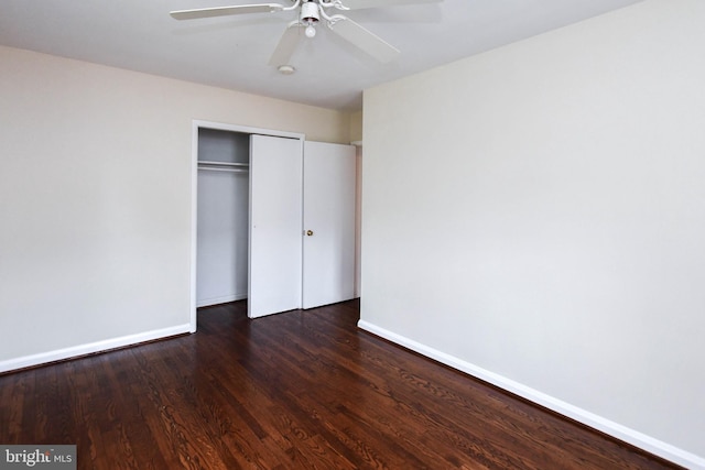 unfurnished bedroom with dark hardwood / wood-style floors, ceiling fan, and a closet