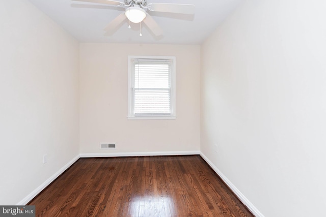 spare room featuring dark wood-type flooring and ceiling fan