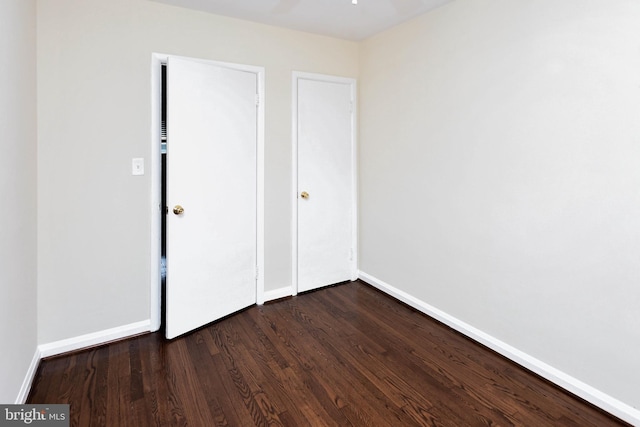 unfurnished bedroom with dark hardwood / wood-style flooring