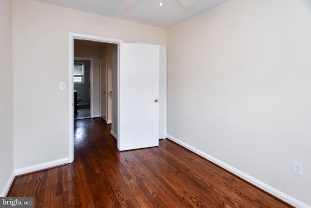 unfurnished room with dark hardwood / wood-style flooring and ceiling fan