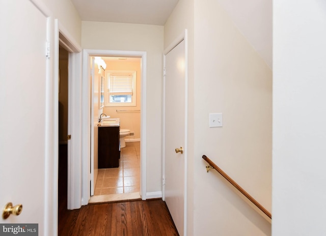 hallway with dark wood-type flooring and sink