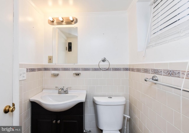 bathroom featuring vanity, tile walls, crown molding, and toilet