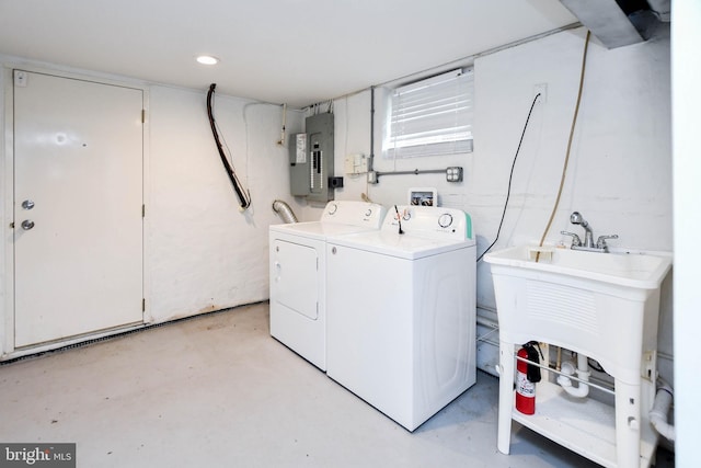 laundry room with washing machine and dryer, sink, and electric panel