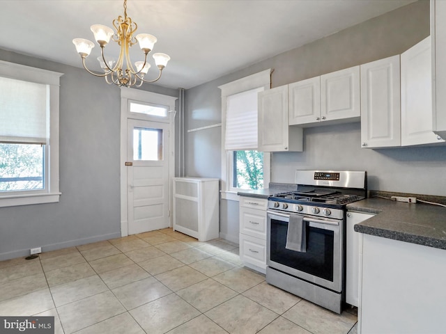 kitchen featuring white cabinetry, stainless steel gas stove, hanging light fixtures, a notable chandelier, and light tile patterned flooring