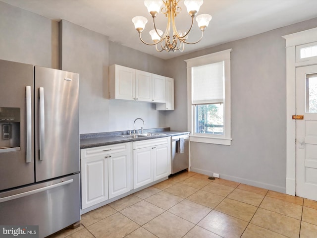 kitchen featuring a wealth of natural light, sink, appliances with stainless steel finishes, and a chandelier