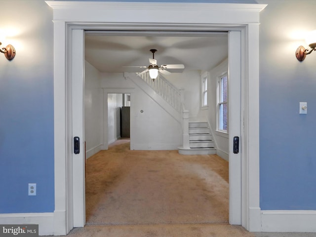 unfurnished living room with light carpet and ceiling fan