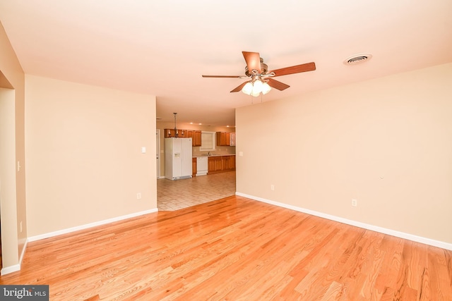 unfurnished living room featuring light wood-type flooring and ceiling fan