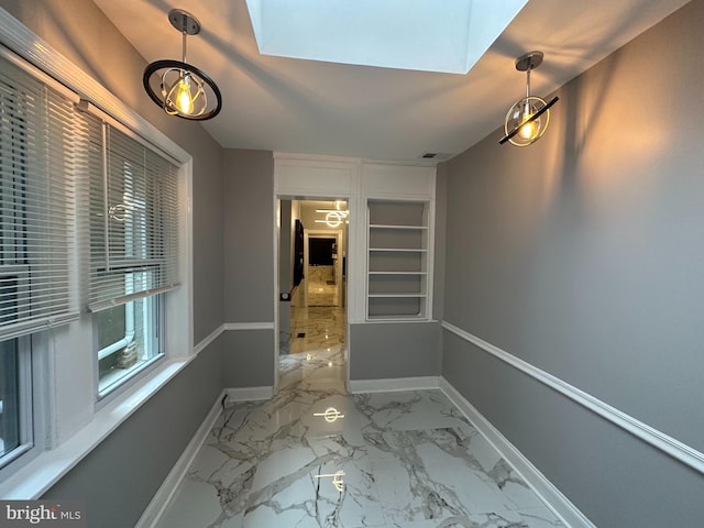 interior space with built in shelves and a skylight