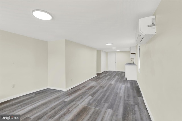 basement with sink, dark wood-type flooring, and a wall mounted air conditioner