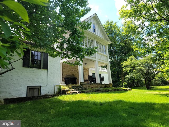 rear view of house featuring a lawn