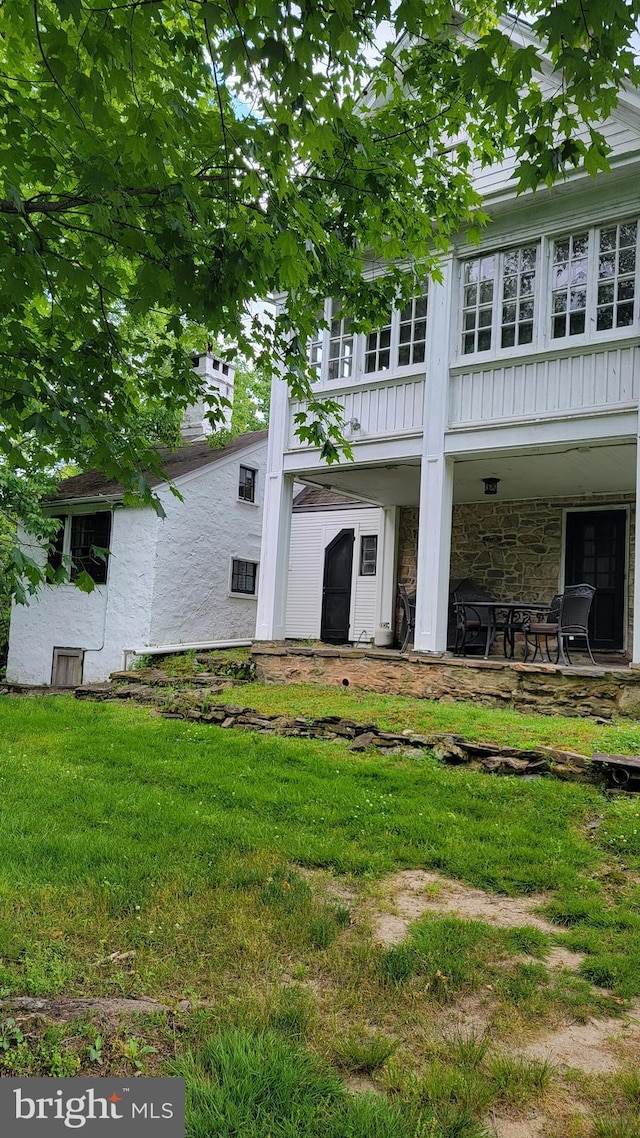 rear view of house featuring a yard