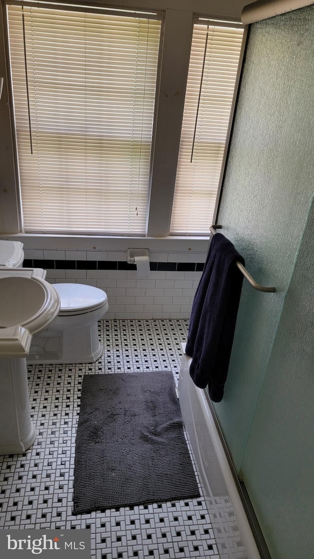 bathroom featuring toilet and enclosed tub / shower combo