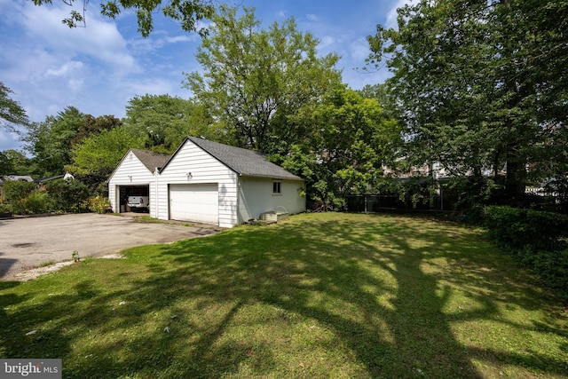 view of yard featuring a garage and an outbuilding